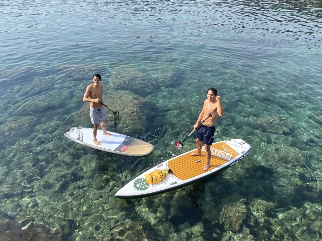 Deux paddleurs sur une eau transparente dans une crique de la Costa Brava