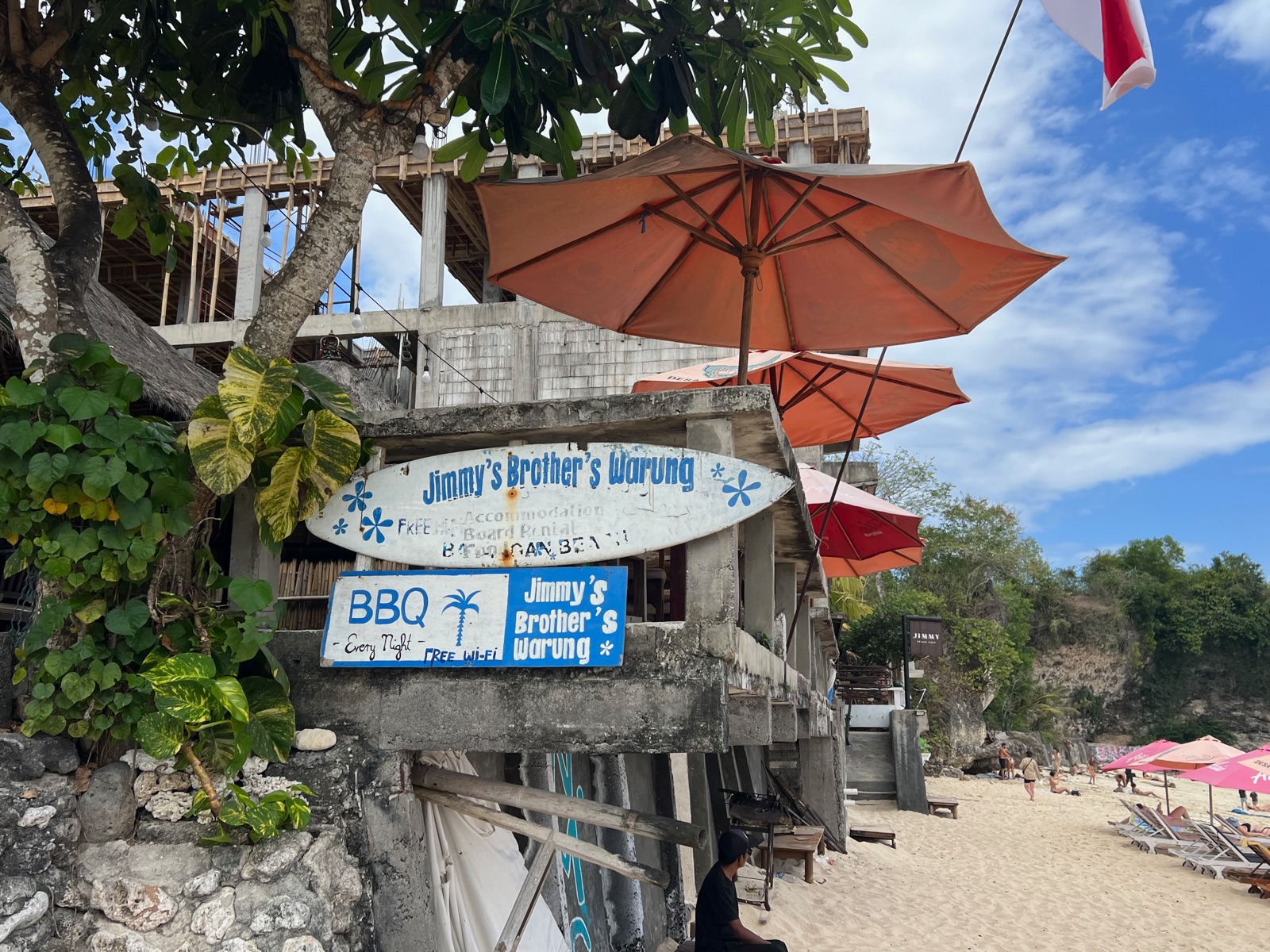 Warung et panneau de bois en haut de la plage de Balangan à Bali