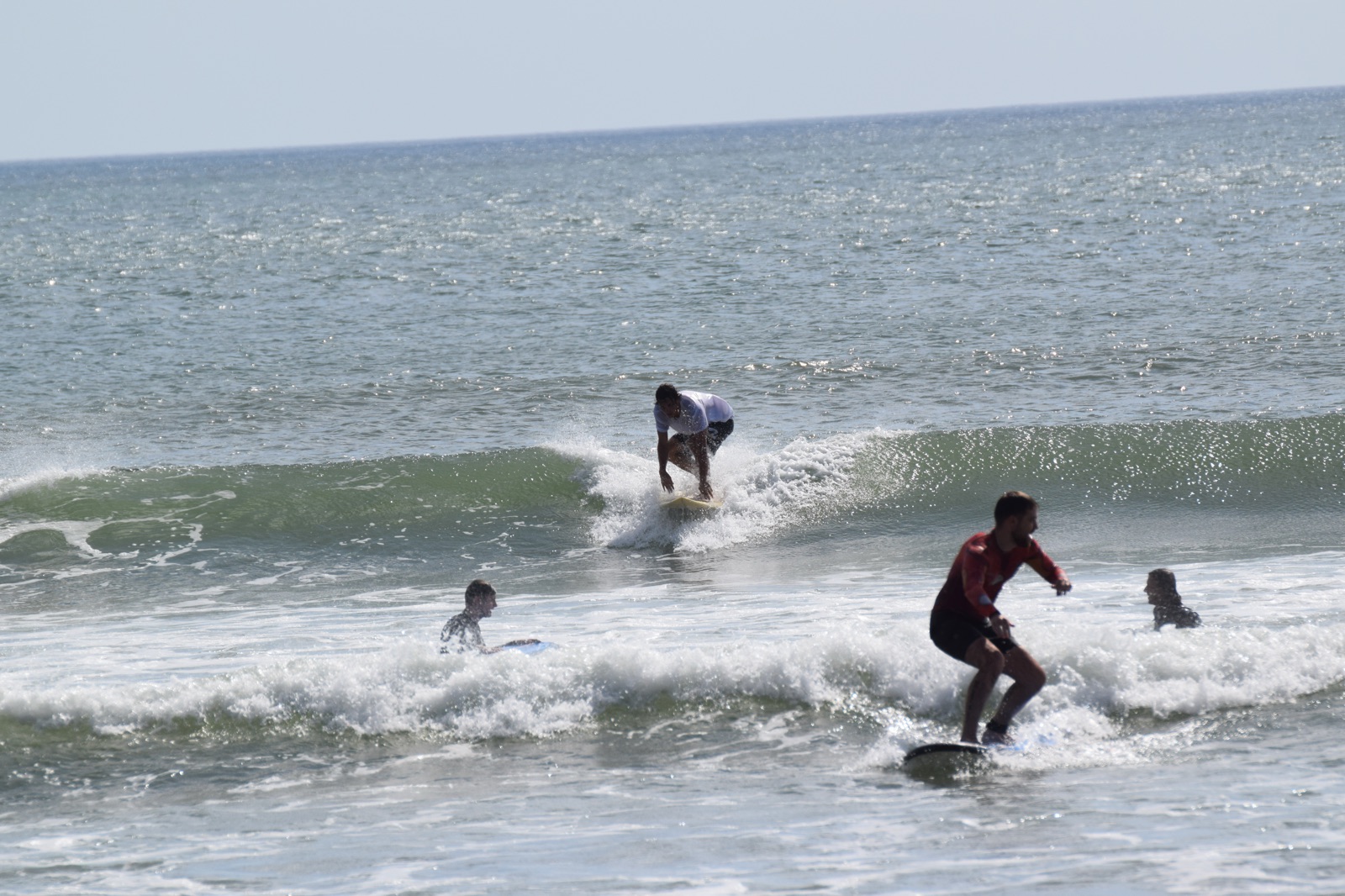 Surfeurs débutants dans les vagues de la plage de Kuta à Bali