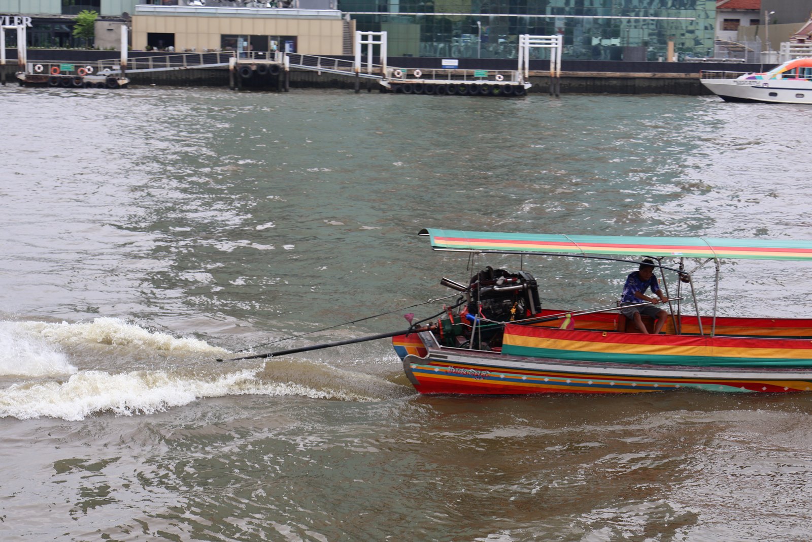Bateau à longue queue coloré filant sur la Chao Phraya