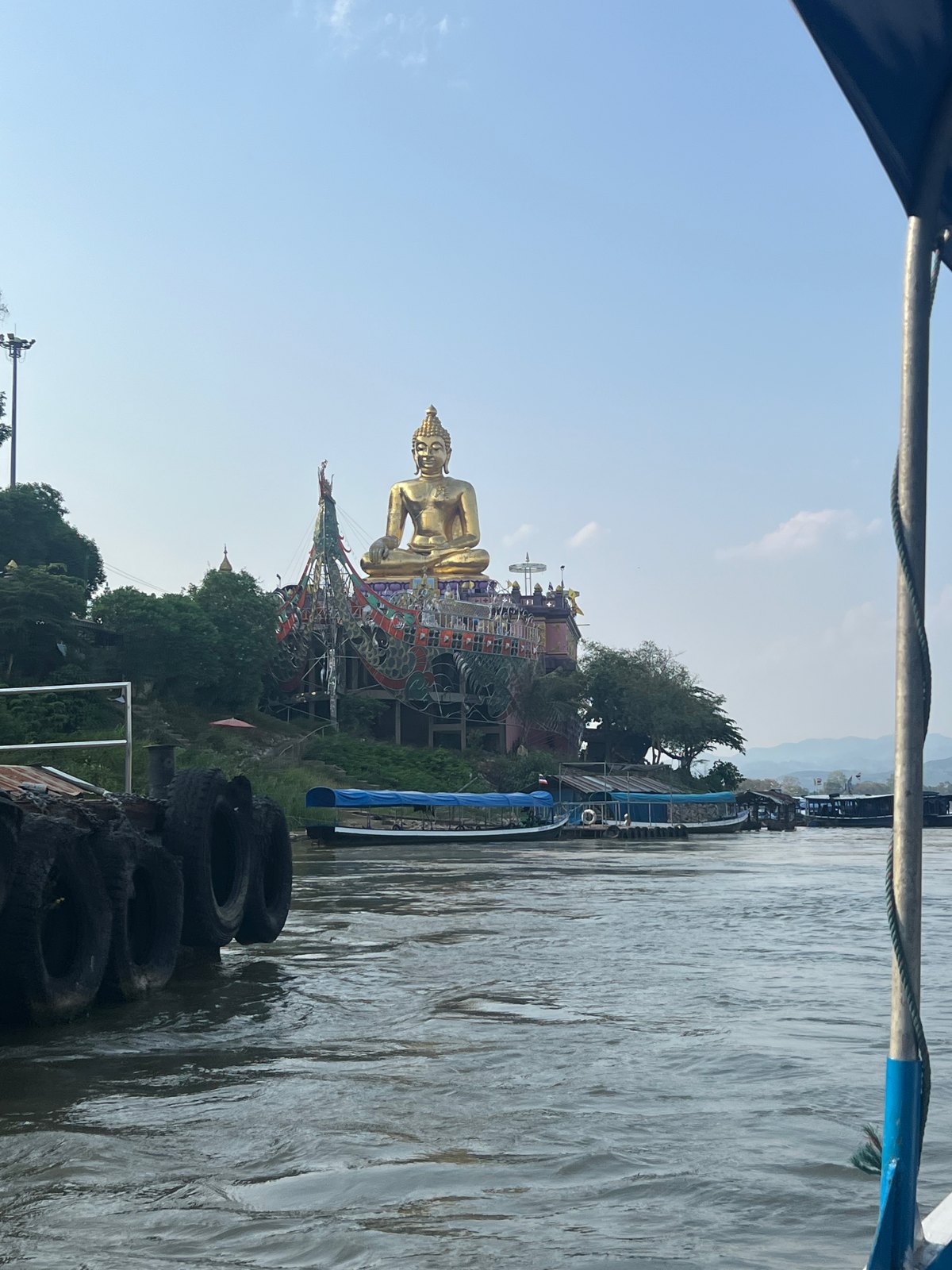 Bouddha doré au bord du Mékong vu depuis un bateau