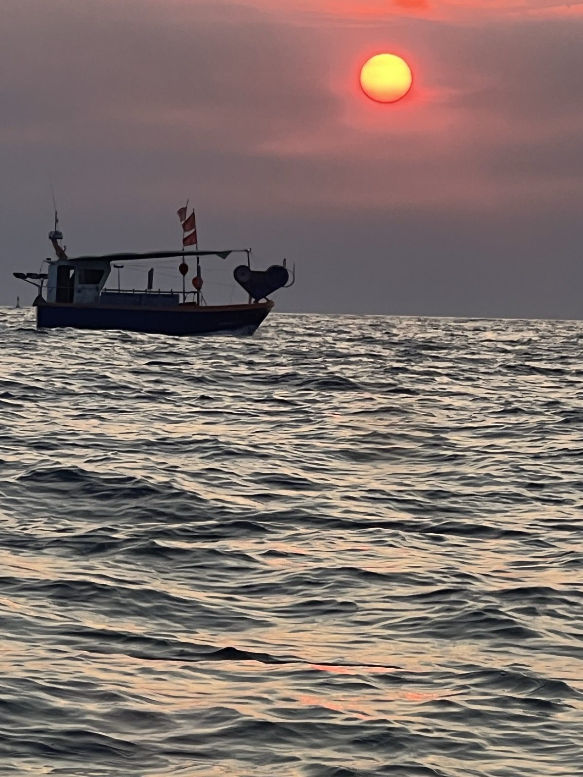 Bateau de pêche au lever du soleil au large de Cala Montgó