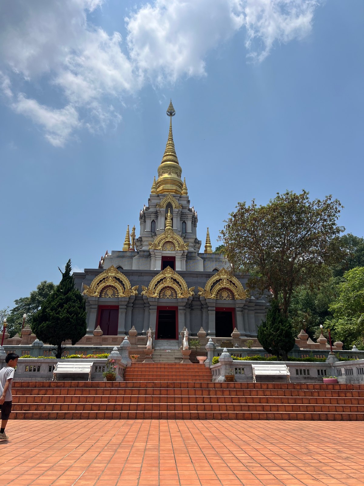 Chedi blanc et doré sur les hauteurs de Doi Mae Salong, sous un ciel bleu
