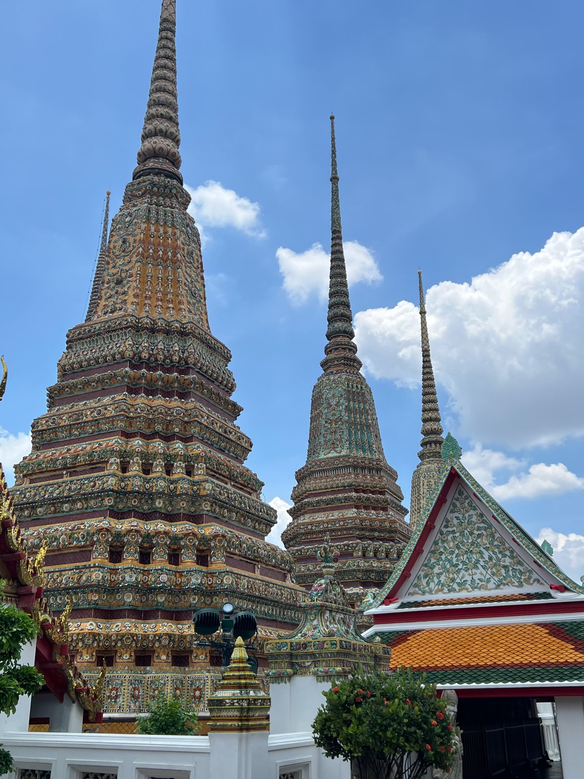 Chedis couverts de céramique colorée au Wat Pho sous un ciel bleu