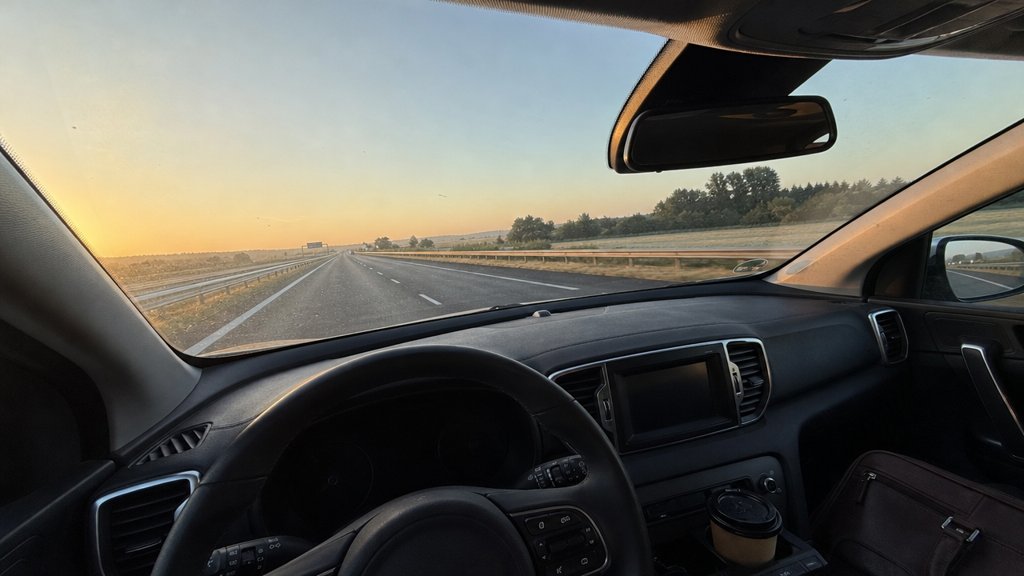 Vue depuis le siège conducteur sur l'autoroute à l'aube, café et sacoche de travail sur le siège passager