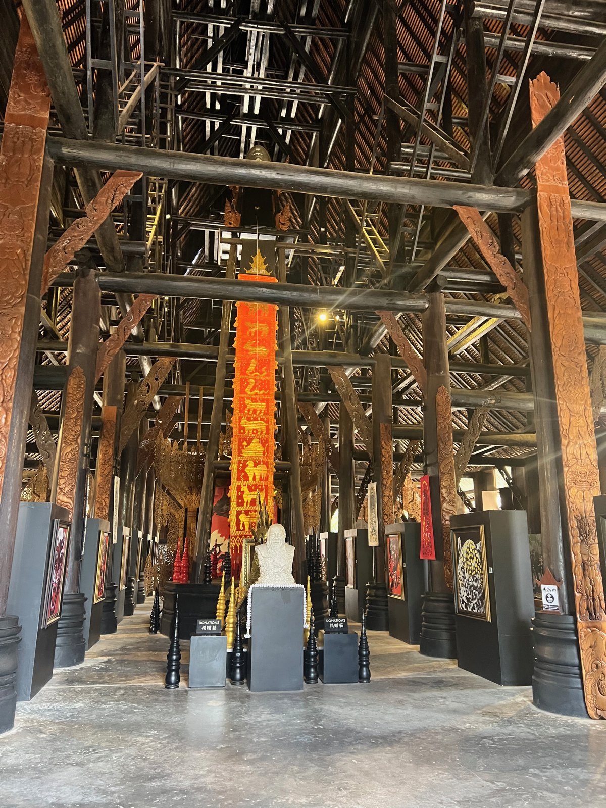 Intérieur de la grande salle en bois sombre de la Maison noire