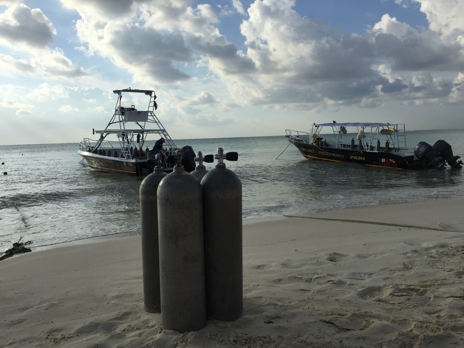 Bouteilles de plongée et bateaux sur la plage de Playa del Carmen