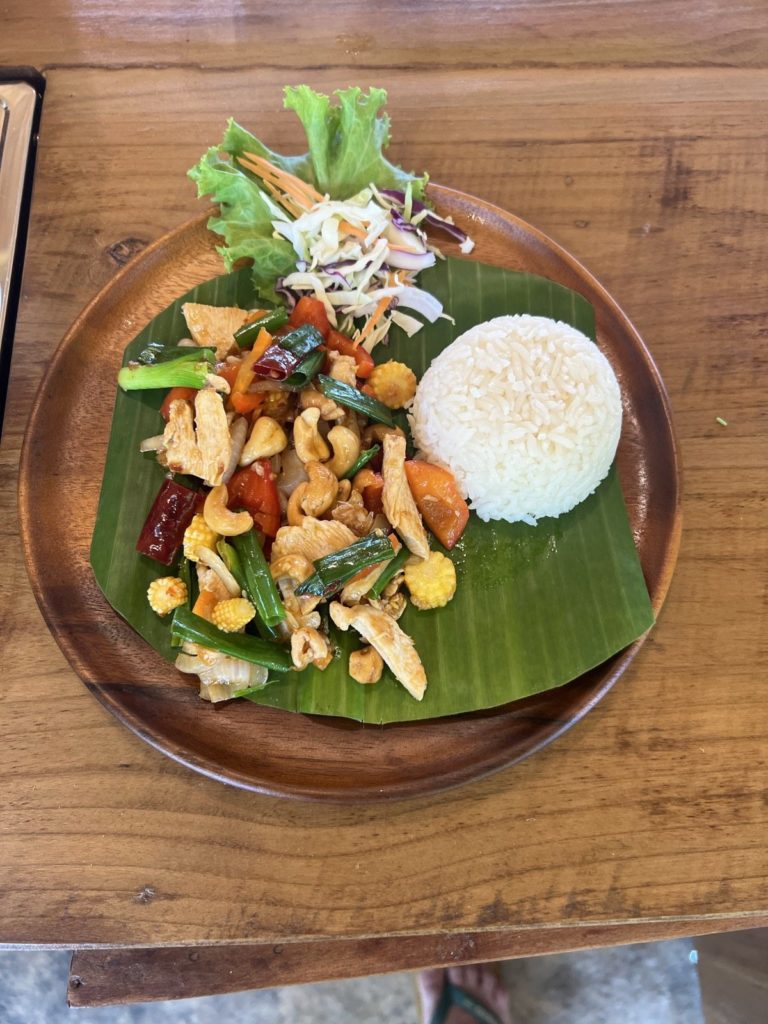 Poulet aux noix de cajou servi sur feuille de bananier avec du riz