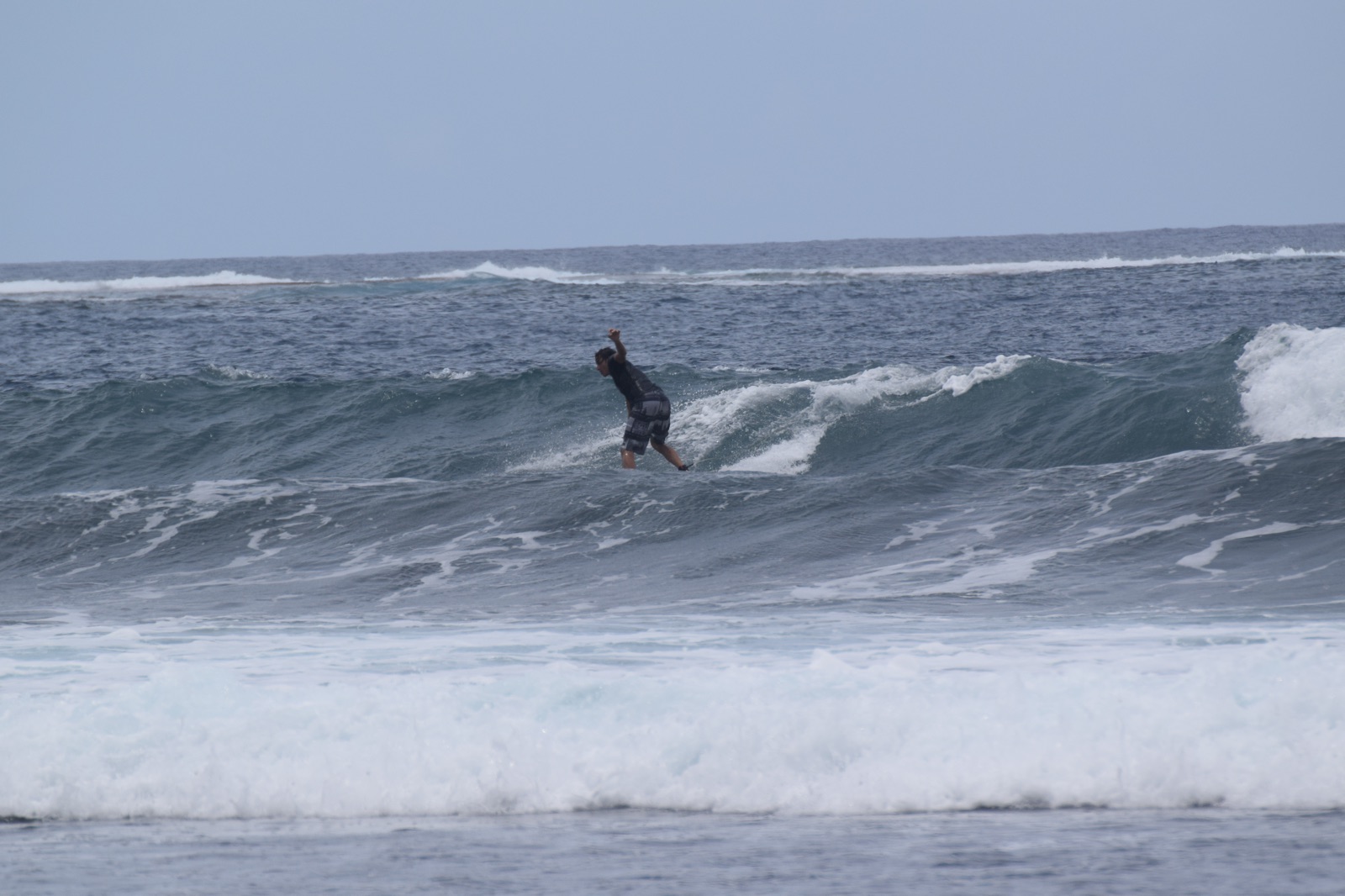 Surfeur sur une vague du récif à Papara, Tahiti