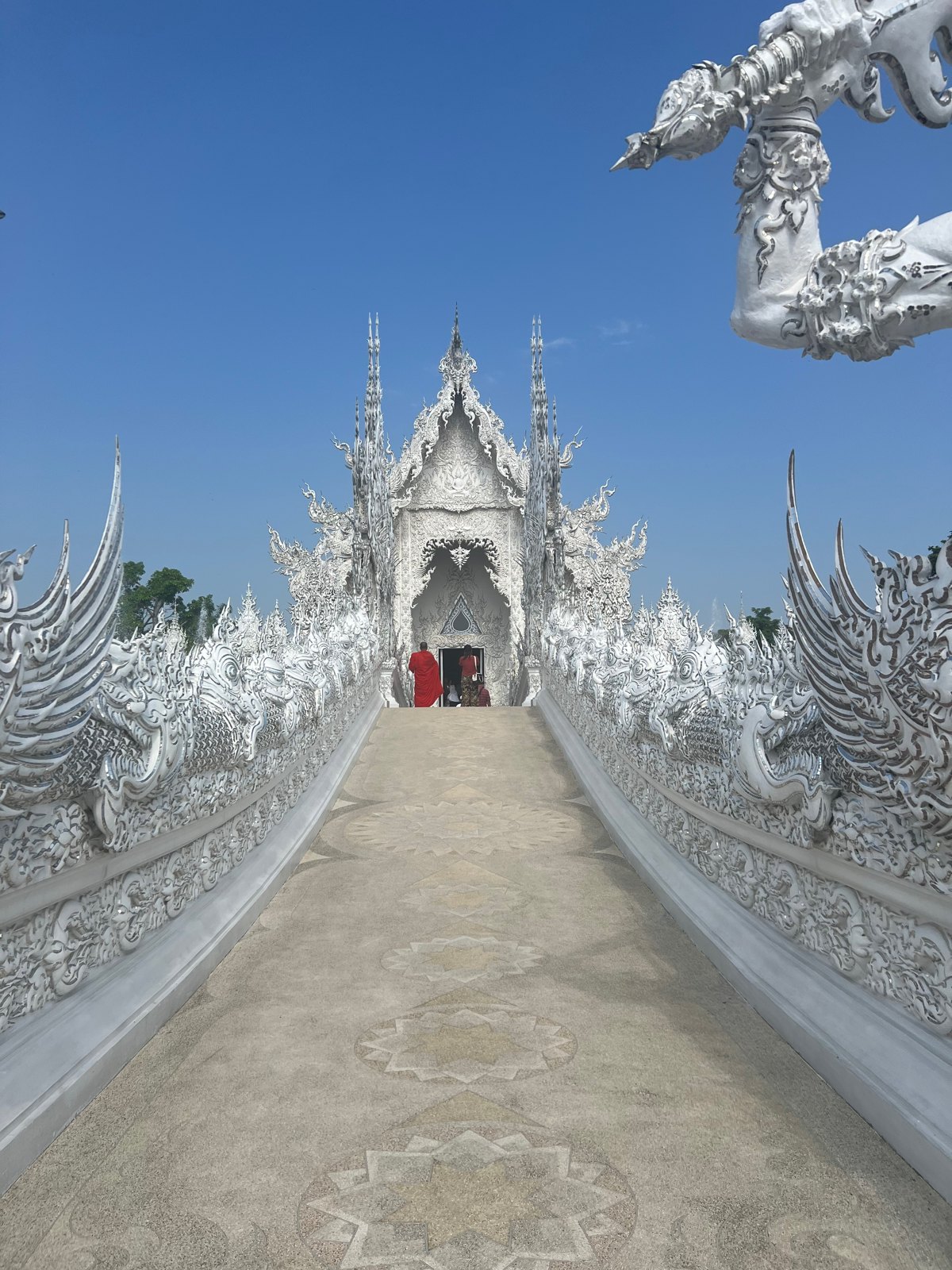 Pont menant au Temple blanc entre des sculptures blanches