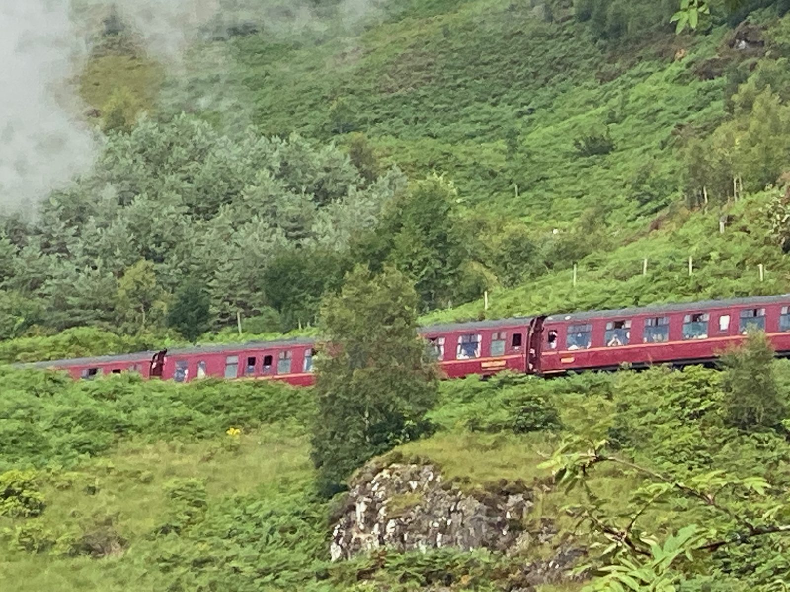 Le train à vapeur Jacobite et ses voitures rouges près de Glenfinnan