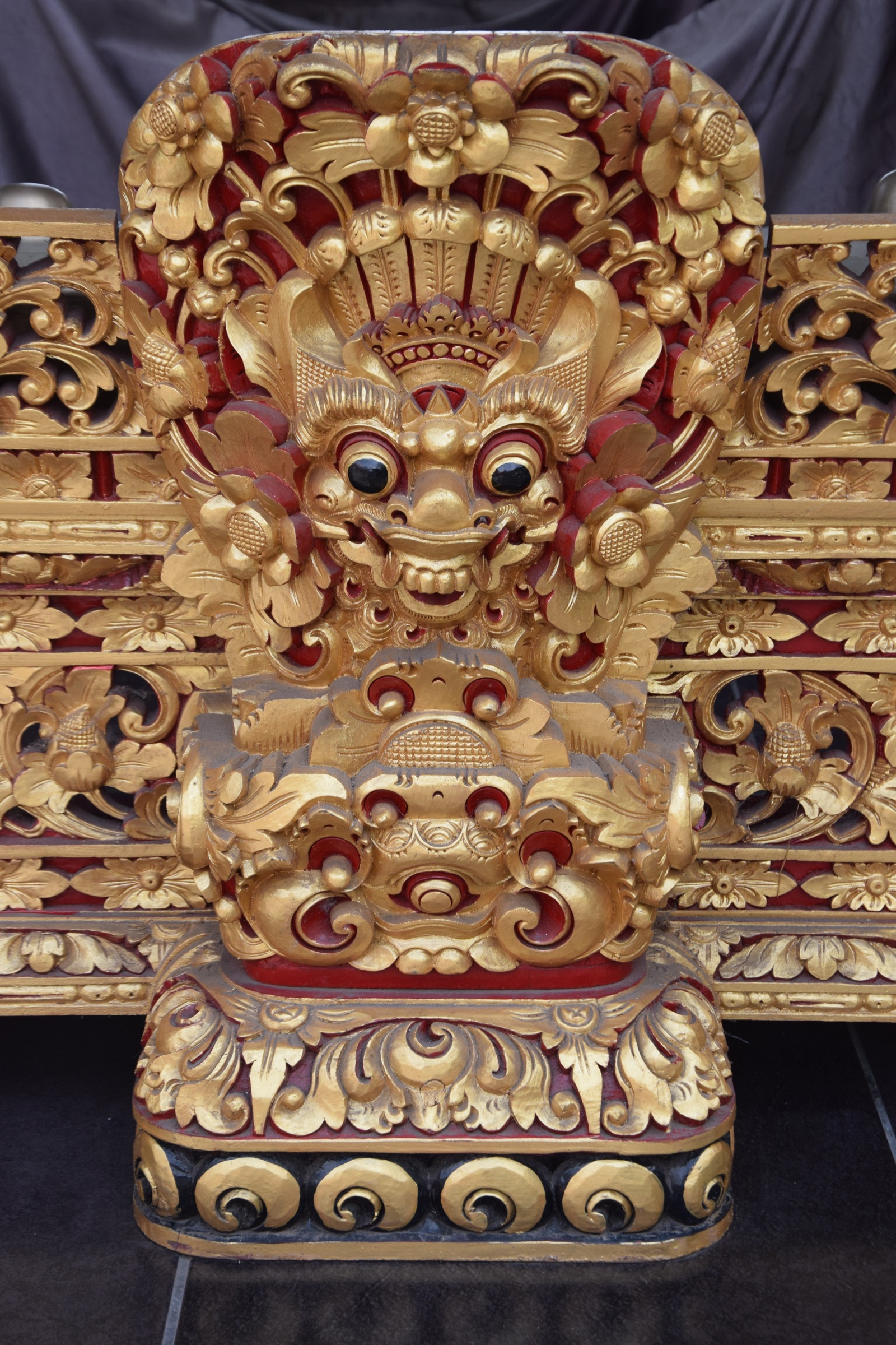 Sculpture dorée d'un visage de Boma sur une porte de temple à Ubud