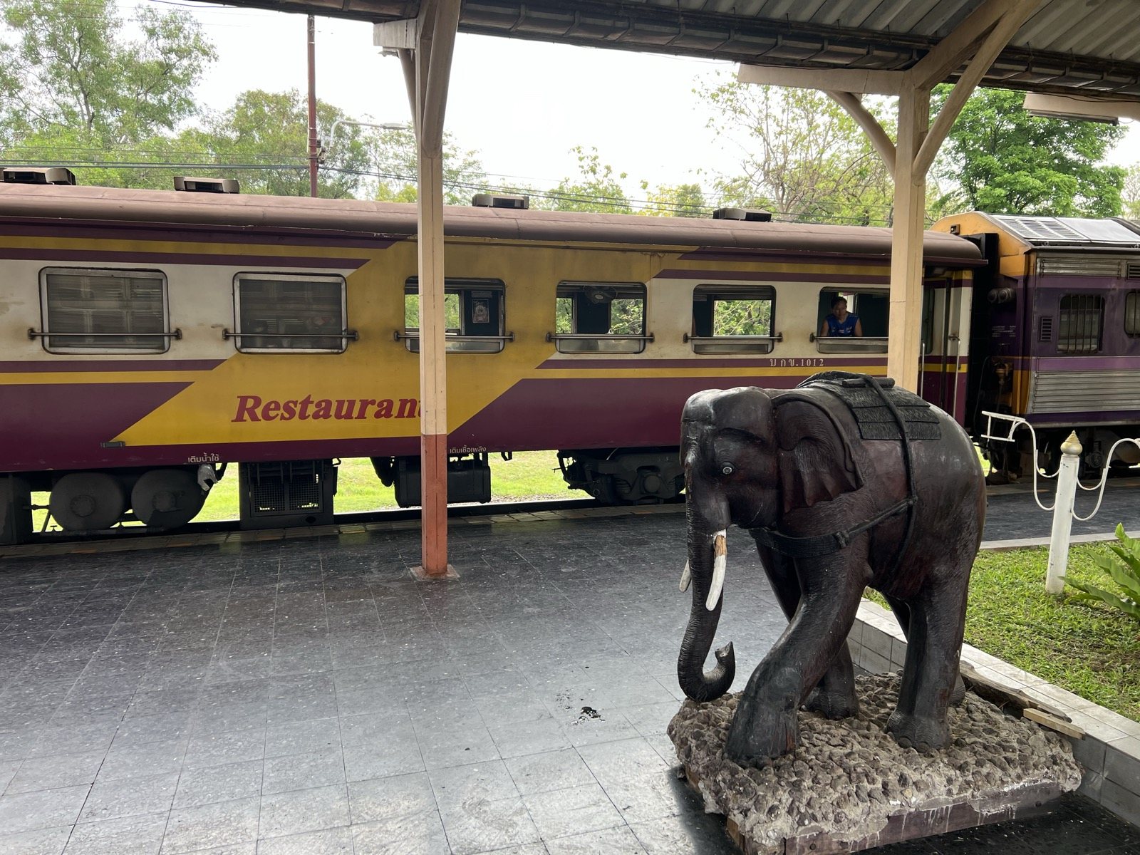 Voiture-restaurant et statue d'éléphant sur le quai de Chiang Mai