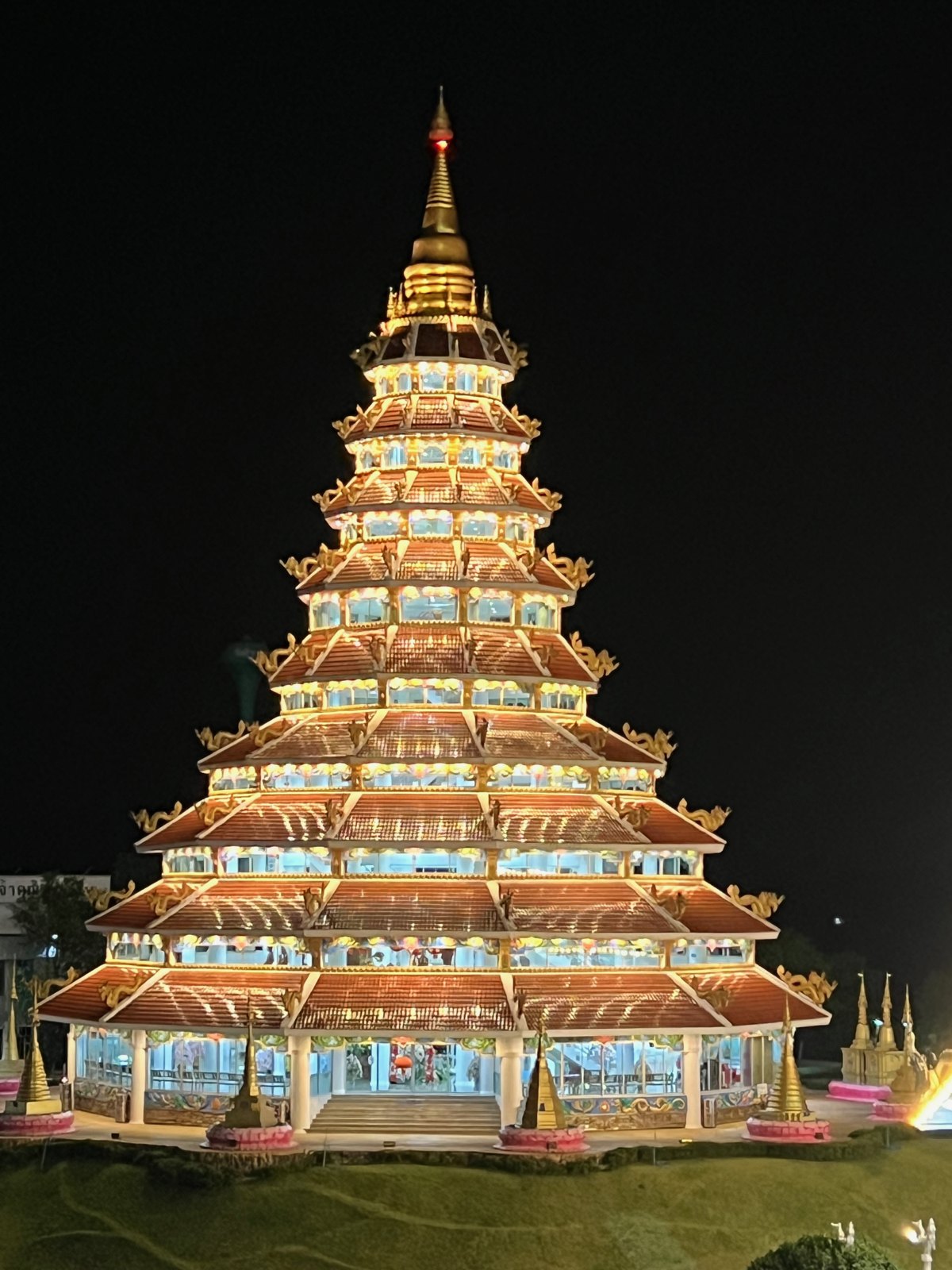 Pagode de neuf étages illuminée la nuit au Wat Huay Pla Kang de Chiang Rai